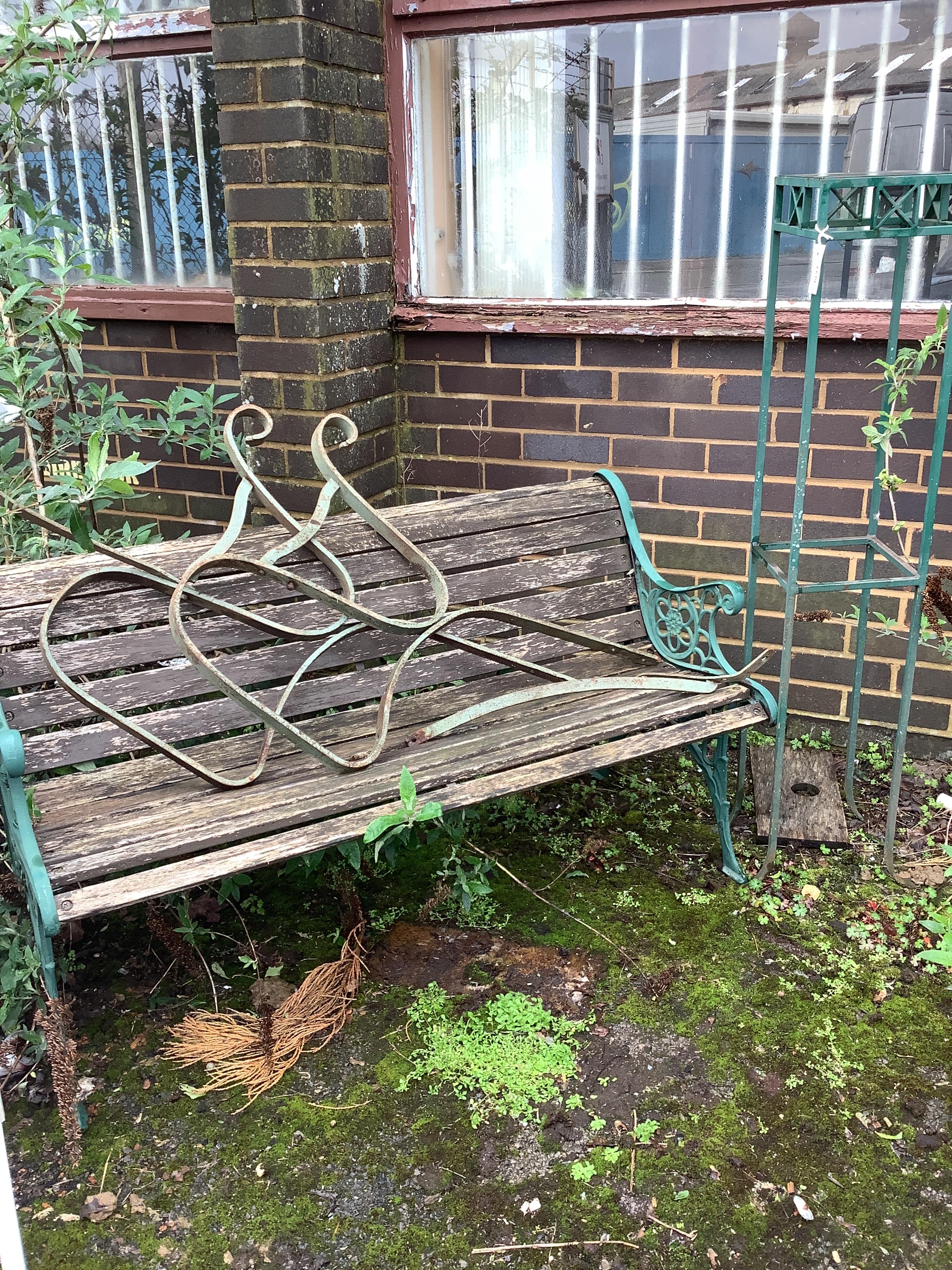 A slatted cast metal garden bench, width 127cm, height 70cm, together with a pair of wrought iron bench ends and a stand